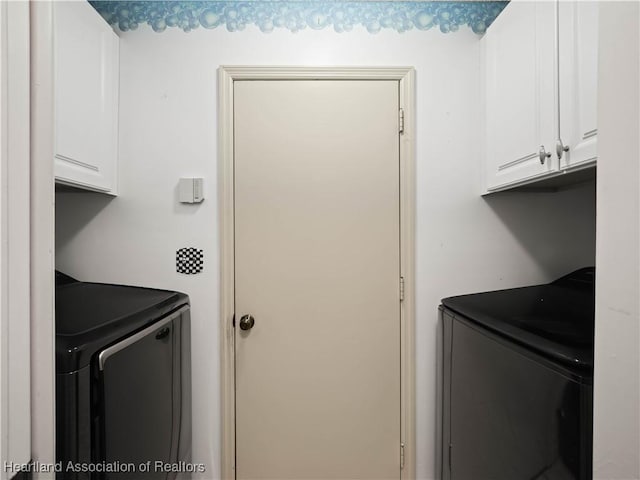 clothes washing area with cabinets and washer and dryer