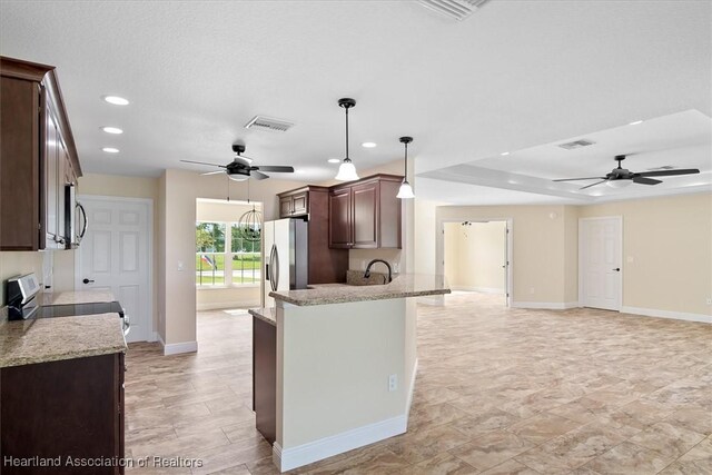 kitchen with a kitchen breakfast bar, hanging light fixtures, stainless steel fridge, light stone countertops, and range