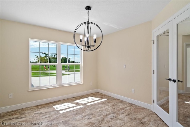 unfurnished dining area featuring french doors and an inviting chandelier