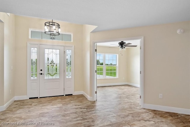 entryway with ceiling fan with notable chandelier