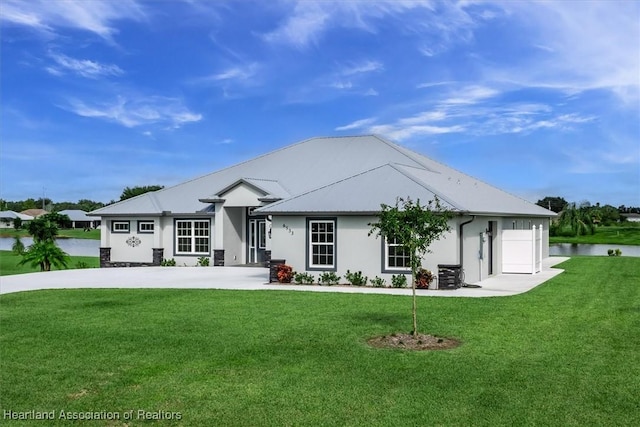 back of property featuring a lawn, a water view, and central AC