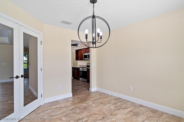 unfurnished dining area with french doors and an inviting chandelier