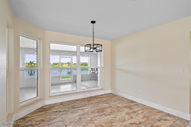 unfurnished dining area featuring an inviting chandelier