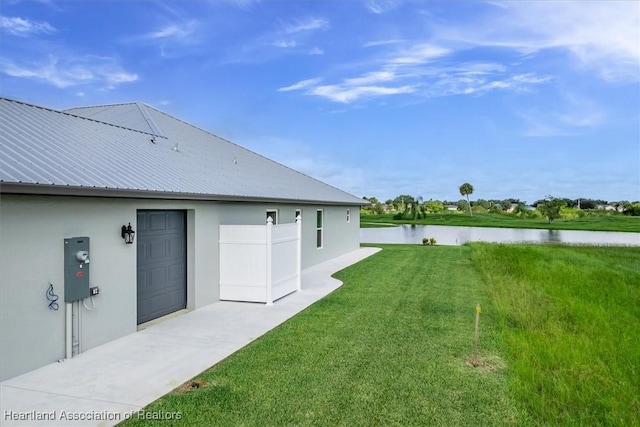 view of yard featuring a water view and a garage