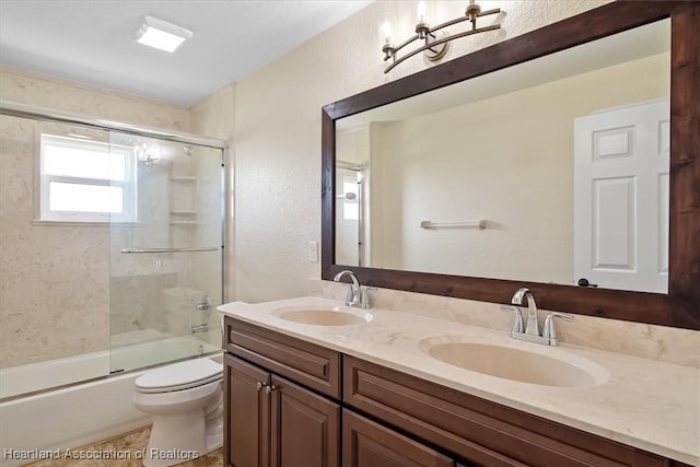 full bathroom with shower / bath combination with glass door, tile patterned floors, vanity, and toilet