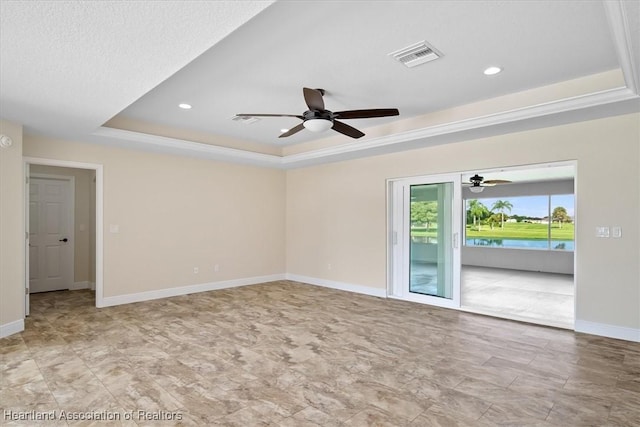 empty room featuring a tray ceiling, ceiling fan, and ornamental molding