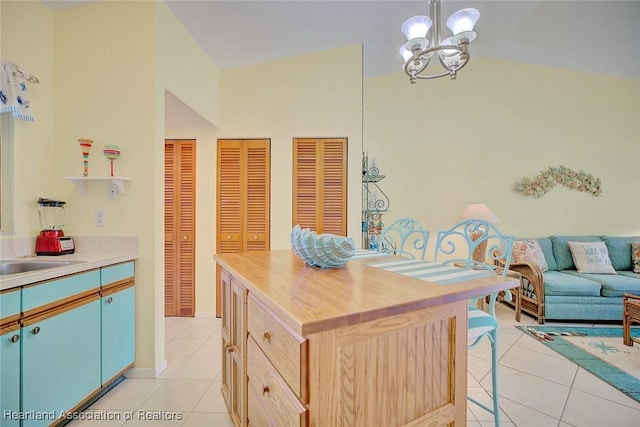 kitchen with a center island, light brown cabinets, hanging light fixtures, a notable chandelier, and light tile patterned flooring