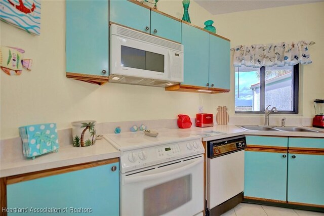 kitchen featuring sink, light tile patterned flooring, and white appliances