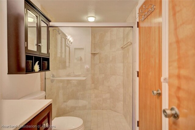 bathroom with an enclosed shower, vanity, and toilet