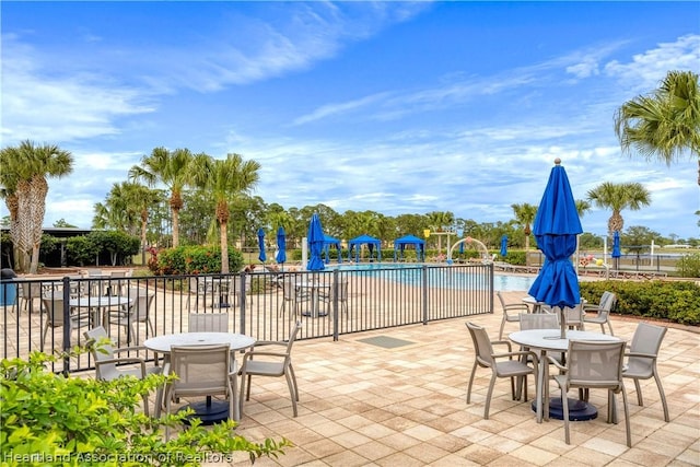 view of patio featuring pool water feature and a community pool