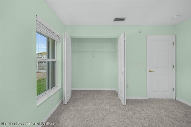 unfurnished bedroom with carpet floors, a closet, visible vents, and baseboards