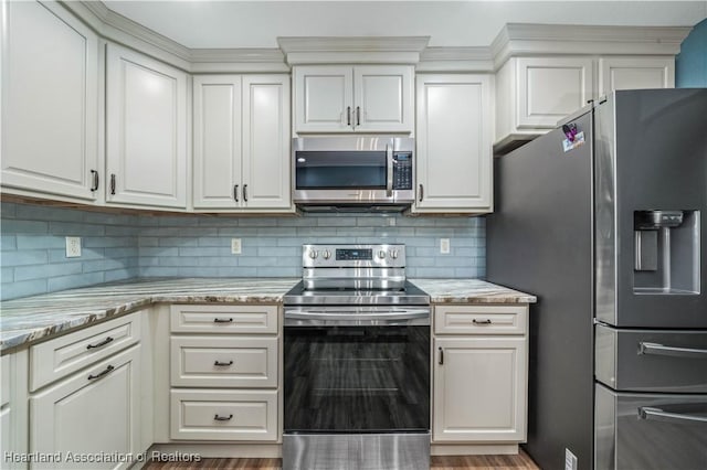 kitchen with stainless steel appliances, tasteful backsplash, light stone countertops, and white cabinets