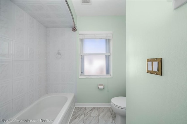 bathroom featuring toilet, marble finish floor, visible vents, and baseboards