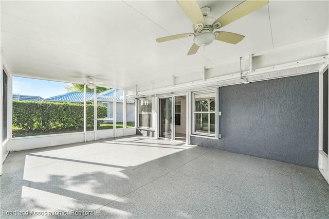 unfurnished sunroom with ceiling fan