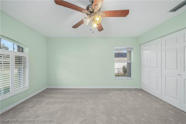 unfurnished bedroom with carpet floors, a closet, visible vents, and baseboards