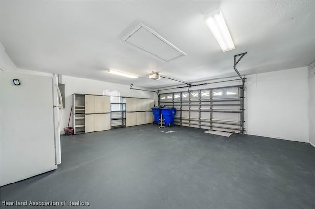 garage with a garage door opener and freestanding refrigerator