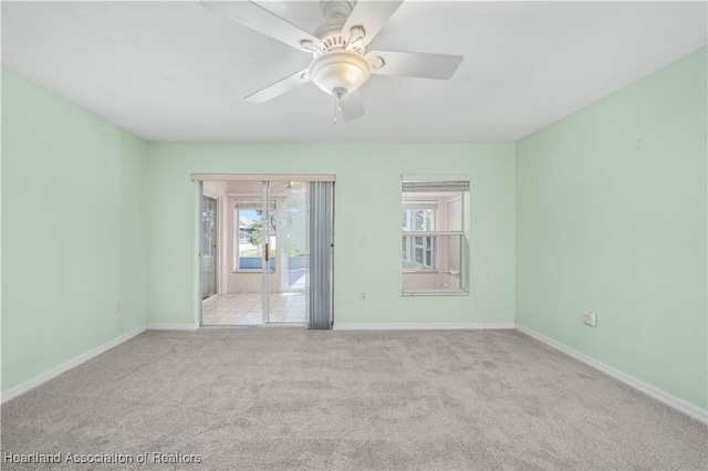 empty room featuring baseboards, a ceiling fan, and carpet flooring