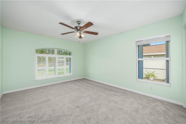 unfurnished room with carpet floors, plenty of natural light, baseboards, and a ceiling fan