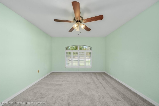 carpeted spare room featuring a ceiling fan, lofted ceiling, and baseboards