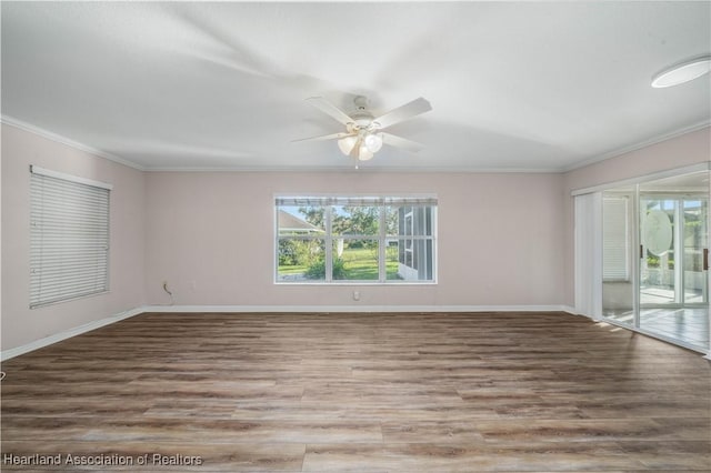 empty room with baseboards, ornamental molding, and wood finished floors