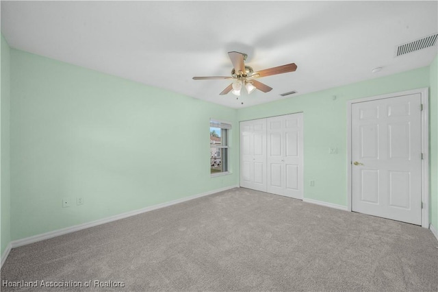 unfurnished bedroom featuring carpet floors, a closet, visible vents, ceiling fan, and baseboards