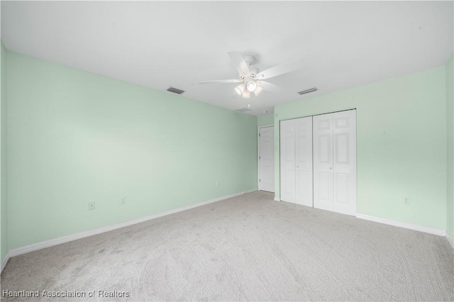 unfurnished bedroom featuring a closet, carpet, visible vents, and baseboards