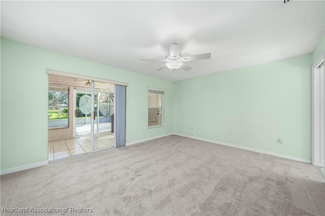 carpeted empty room with baseboards and a ceiling fan