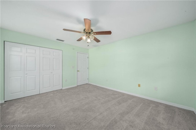 unfurnished bedroom with baseboards, visible vents, ceiling fan, carpet, and a closet