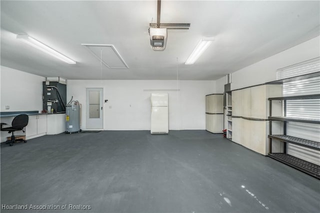 garage featuring heating unit, water heater, a garage door opener, and freestanding refrigerator