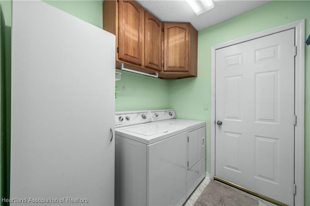 clothes washing area with washing machine and dryer and cabinet space