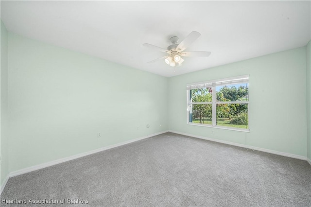 carpeted empty room with baseboards and a ceiling fan