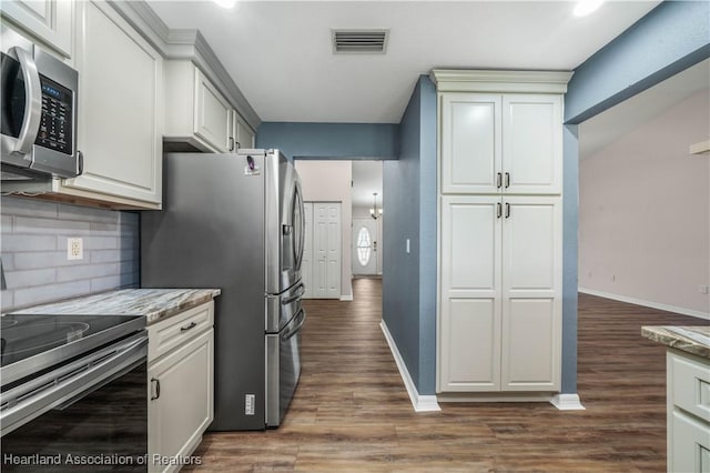 kitchen featuring dark wood-style flooring, visible vents, baseboards, appliances with stainless steel finishes, and tasteful backsplash