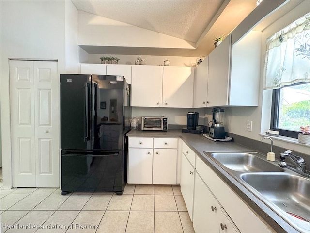 3216 Locust Ave, Lake Placid, FL 33852 - kitchen featuring freestanding refrigerator, vaulted ceiling, white cabinetry, light tile patterned floors, and a textured ceiling
