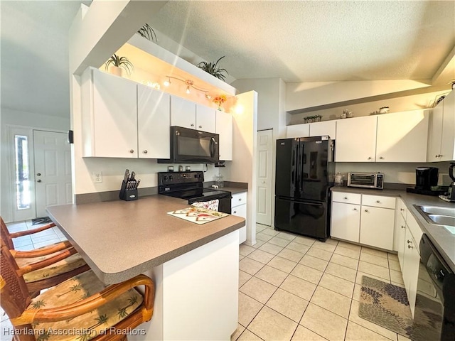 3216 Locust Ave, Lake Placid, FL 33852 - kitchen with black appliances, a peninsula, light tile patterned floors, a textured ceiling, and white cabinetry