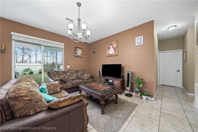 tiled living room with a notable chandelier