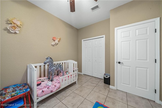 tiled bedroom with ceiling fan and a closet