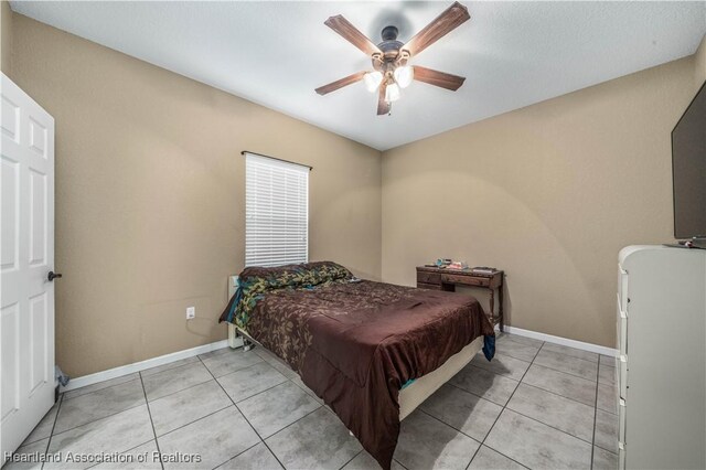 tiled bedroom featuring ceiling fan