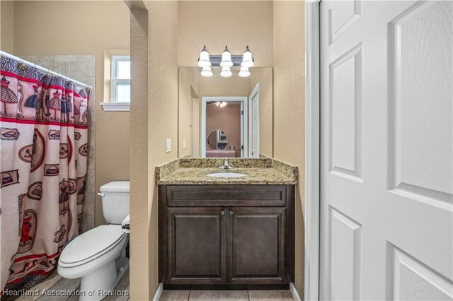 bathroom with a shower with shower curtain, vanity, toilet, and tile patterned flooring