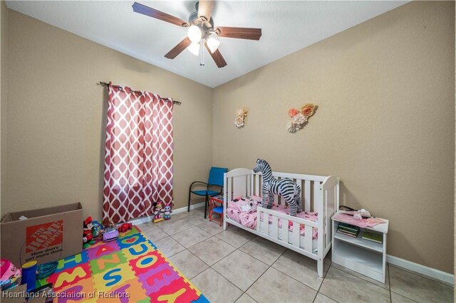 tiled bedroom with a nursery area and ceiling fan