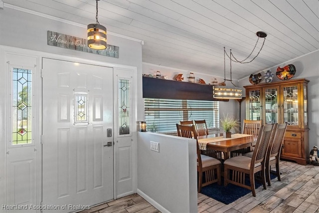 dining space featuring crown molding, wooden ceiling, a wealth of natural light, and wood tiled floor