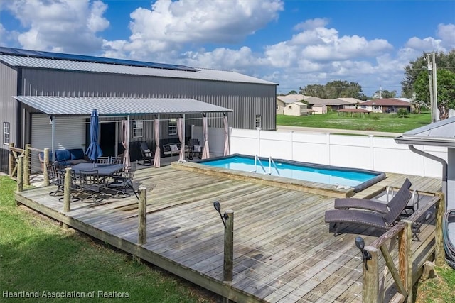 view of swimming pool featuring a wooden deck, a fenced in pool, and fence