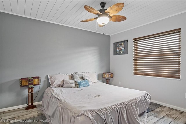 bedroom featuring crown molding, wood ceiling, ceiling fan, wood finished floors, and baseboards