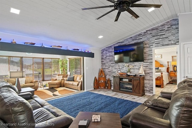 living area featuring lofted ceiling, a large fireplace, wooden ceiling, and a ceiling fan