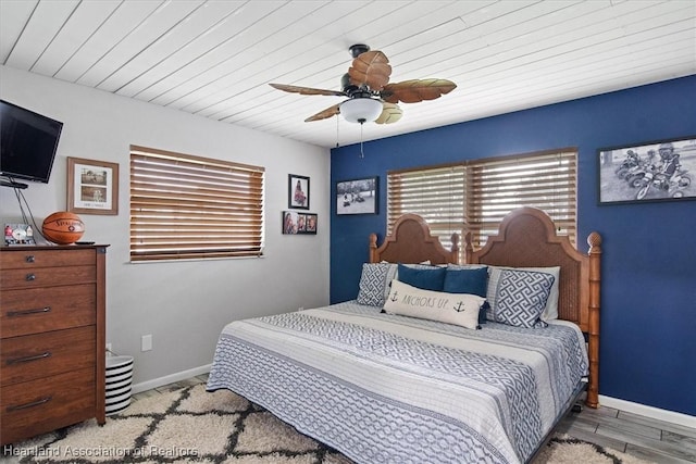 bedroom featuring a ceiling fan, baseboards, and wood finished floors