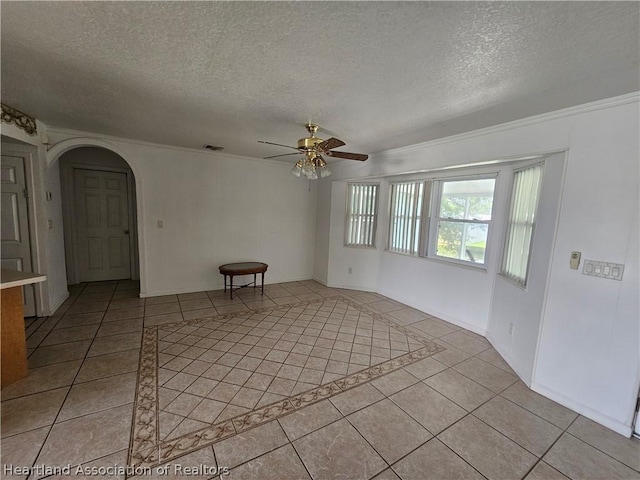 unfurnished room with a textured ceiling, ceiling fan, and light tile patterned flooring