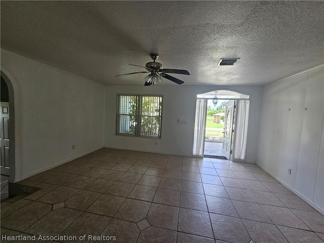 empty room with ceiling fan, light tile patterned floors, and a textured ceiling