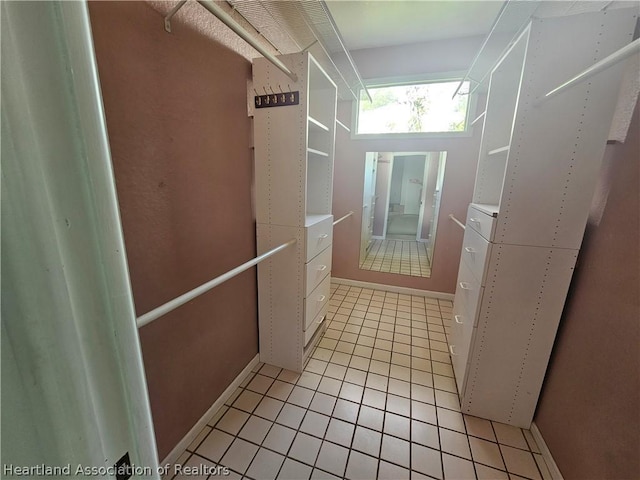 walk in closet with light tile patterned floors