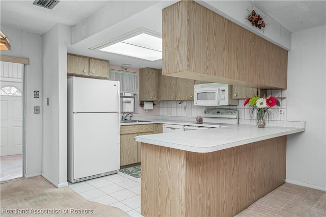 kitchen with light tile patterned flooring, sink, backsplash, kitchen peninsula, and white appliances