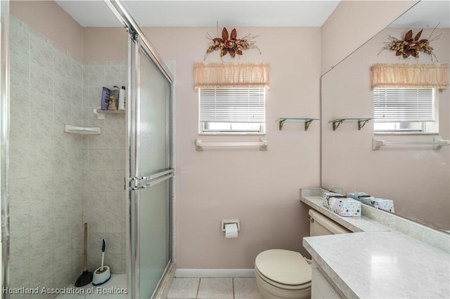 bathroom featuring vanity, a shower with shower door, tile patterned floors, and toilet