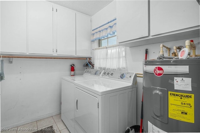 clothes washing area featuring light tile patterned flooring, cabinets, washing machine and dryer, and water heater